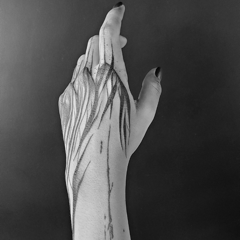 Tatuaje NeoTribal Freehand que enmarca la anatomía de una mano